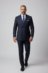 Man wearing navy pinstripe double-breasted suit with tailored fit and white shirt.
